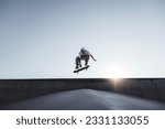 Skater doing kickflip on the ramp at skate park - Stylish skaterboy training outside - Extreme sport life style concept