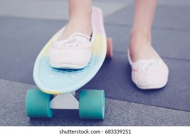 Skater Girl Rides On Blue,pink Cruiser Skate Board In Tennis Shoes.Feet Of Young Girl Riding On Little Cruiser Skateboard.Fun Sport Activity For Young,active People.Fun Outdoor Activity For Youth