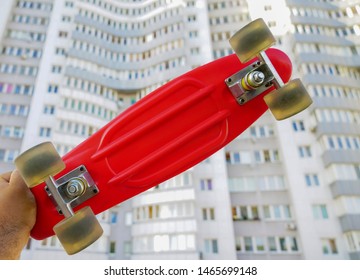 Skater Hand  Holding Red Skateboard Deck  On White House  Background