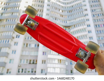 Skater Hand  Holding Red Skateboard Deck  On White House  Background