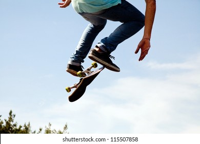 Skater jumps high in air on background blue sky - Powered by Shutterstock