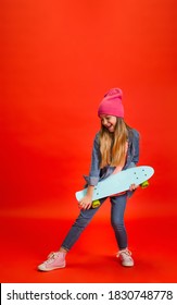 Skater Rock. Caucasian Little Girl's Portrait Isolated On Red Studio Background. Cute Stylish Model. Concept Of Human Emotions, Facial Expression, Sales, Ad, Childhood, Education. Copyspace.