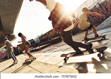 Skating Is Their Life. Group Of Young People Skateboarding While Hanging Out At The Skate Park Outdoors