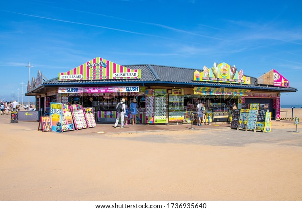 Skegness UK, 21st May 2020: Photo of an ice cream\
vendor and slushie bar on the beach of Skegness in East Lindsey\
district of Lincolnshire, England on a bright sunny summers day\
with blue sky
