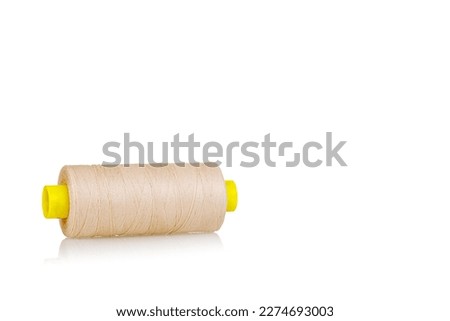 skein of beige color thread macro on a white background close-up