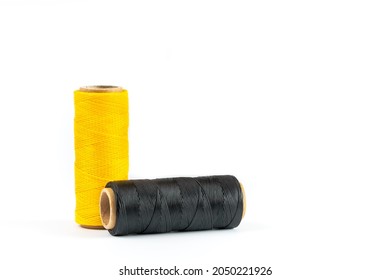 A skein of black and yellow thread. Coils of colored threads on a white background. Waxed sewing thread for leather goods.