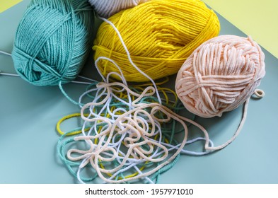 Skeins Of Colored Yarn With Loose Threads On A Colored Background Top View Knitting Concept