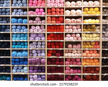 Skeins Of Yarn On A Wooden Rack On The Store Counter.