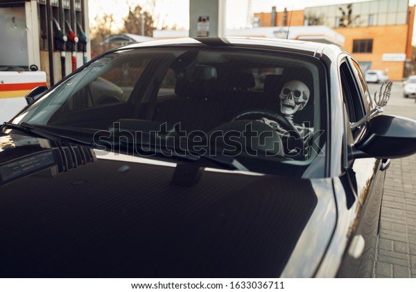 Skeleton in car, fueling\
on gas station