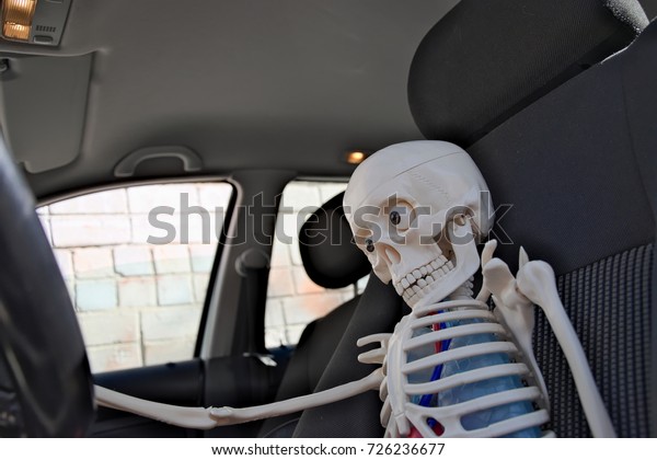 Skeleton is driving in car.\
