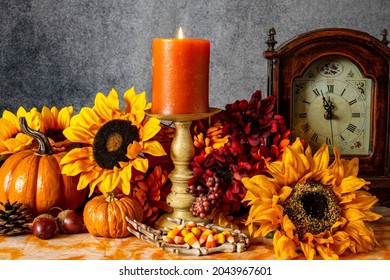 Skeleton Hand Filled With Candy Corn With Sunflowers Pumpkins And Burning Candle