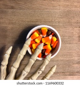 Skeleton Hand Reaching For Halloween Candy Corn