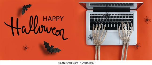 Skeleton Hands Typing In Laptop And Happy Halloween Text