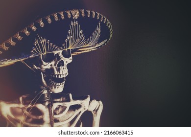 A skeleton wearing a Mexican sombrero, edited in a vintage film style. Smiling skull for Cinco de Mayo with copy space.
