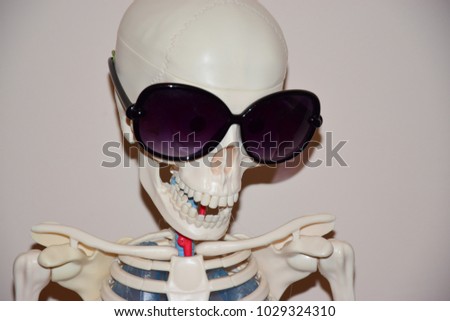 Skeleton of a woman in sunglasses on a sunny day. Protect your eyes from the sun.