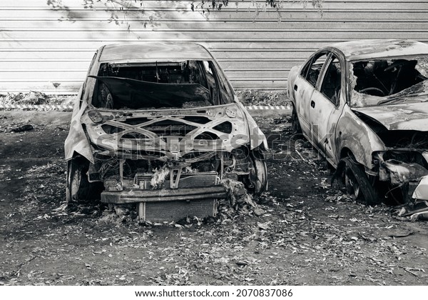 Skeletons of two burnt\
out cars after fire