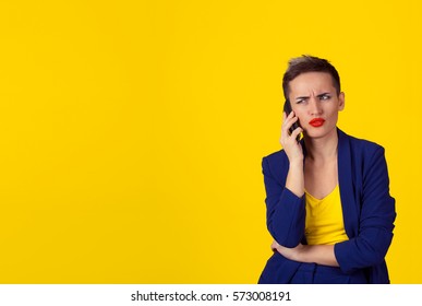 Skeptical Business Woman In Disbelief Talking On Phone Deciding What To Answer Looking To Copy Space Isolated Yellow Background Wall. Negative Human Emotion, Face Expression, Body Language