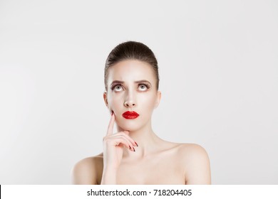 Skeptical  Portrait puzzled young woman thinking has many ideas looking up isolated white gray wall background  Human face expression emotion feeling life perception  Decision making process concept