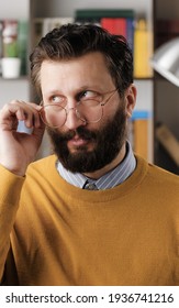 Skepticism, Sarcasm Emotion. Bearded Man In Glasses In Office Or Apartment Room Expressing His Skeptical Attitude And Discontent With His Look. Close Up View