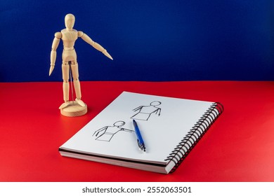 Sketch pad and pencil with artists wooden model figure on a blue background and red base - Powered by Shutterstock