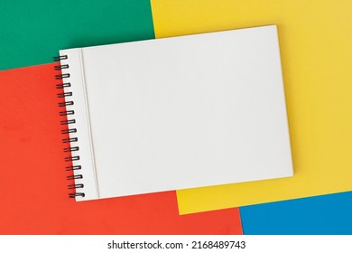 Sketchbook With Metal Spiral On Bright Multi-colored Background, Copy Space