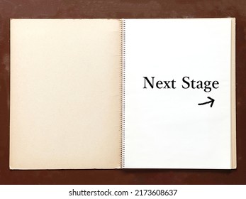 Sketchbook With Next Stage Text Opened On The Desk