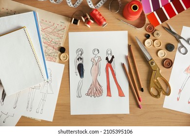 Sketches of fashion clothes and thread supplies at designer's workplace, flat lay - Powered by Shutterstock