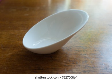 Skew White Porcelain Gravy Boat On Wooden Table