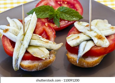 skewer of pickled anchovies, adorned with tomato and mint, cover typical Spanish