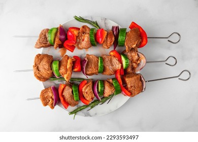 Skewers with raw pork meat pieces with vegetables, pepper and onion for cooking barbecue, kebab or bbq. Top view. Preparation barbeque or shashlik