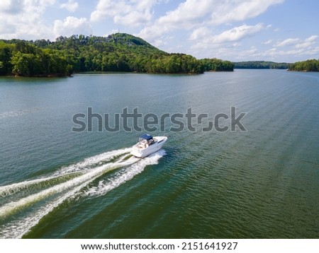 Ski boats at full throttle on an empty lake. Large wake waves behind speed boats.