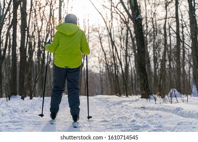 A Ski Boy Stands With His Back To The Camera Against The Background Of A Frosty Winter Forest