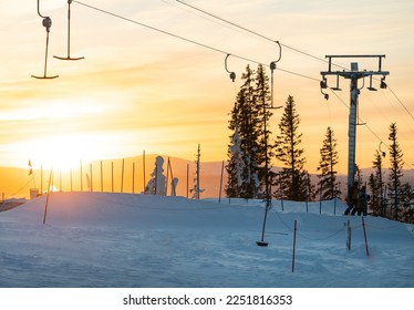 Åre ski center during sunset. Skilifts taking people up the hill. Amazing sunset during sking and snowboarding holiday.  Perfect weather to enjoy the winter holiday in Skandinavia