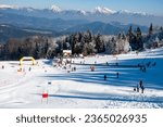 Ski center Stari vrh above the Poljanska dolina with snowy mountains in background