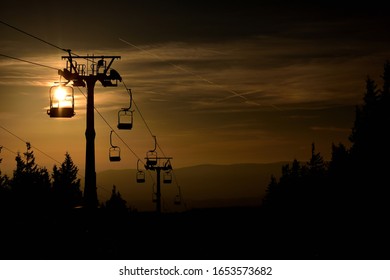 Ski Chair Lift Cableway In The Mountains At Orange Sunrise