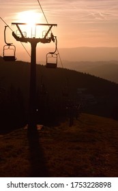 Ski Chair Lift In The Mountains At Pink Sunrise. Vertical Photo.