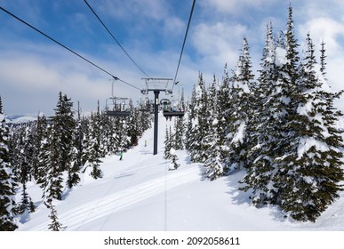 Ski chairlift going up a ski slope in the snowy mountain range of Big Mountain in Whitefish, Montana, at Glacier National Park, USA.