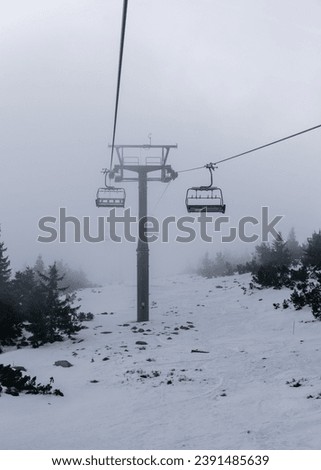Ski chairlift. Heavy snow, poor visibility due to snow and fog