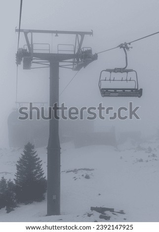 Ski chairlift. Lift for skiers. Heavy snowfall, very poor visibility due to snow and fog.