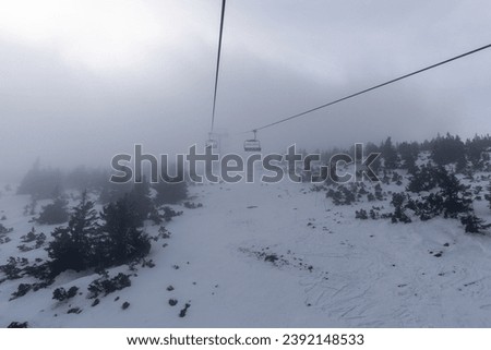 Ski chairlift. Lift for skiers. Heavy snowfall, very poor visibility due to snow and fog.