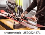 Ski Equipment adjusting by Ski Master. Ski Service and Ski Rental Concept. 