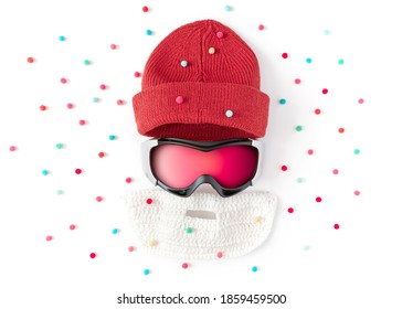 Ski Goggles, Beanie Cap, False Knitted Beard Are On A White Background. Winter Sports Concept. Protection Accessories.  Flat Lay, Top View.