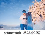 Ski Goggles Of Snowboarder With The Reflection Of Snowed Mountains. Winter Sports. Portrait Of Woman On The Background Of Mountains and Sunset.   Holding a Snowboard And Wearing Ski Glasses. 