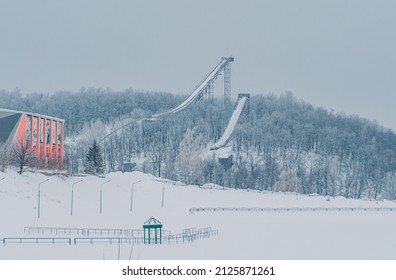 Ski Jumping Slopes Or Towers In Tatarstan, Russia. Ramps Surrounded By Snow-covered Trees On A Hill . Ski Jumping Ramp