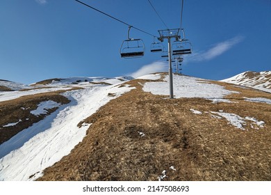 Ski lift in the Alps with lack of snow after heavy melting