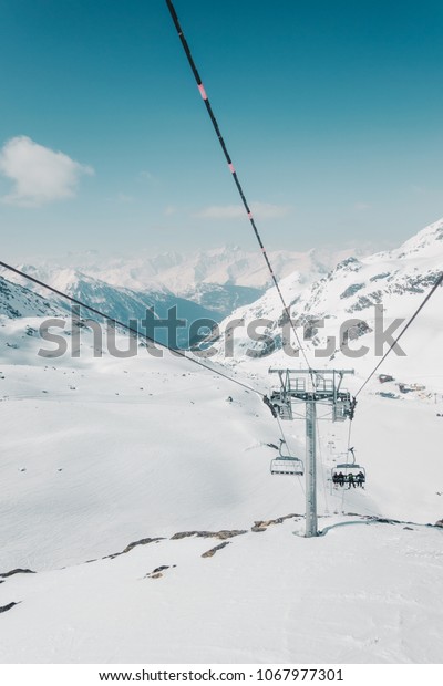 Ski lift cable car and mountains landscape, covered\
with snow