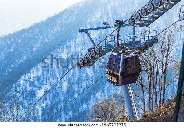 Ski lift\
cable, Ropeway, and cableway transport system for skiers with fog\
on valley background. High quality\
photo