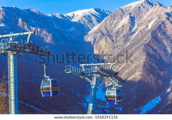 Ski lift\
cable, Ropeway, and cableway transport system for skiers with fog\
on valley background. High quality\
photo