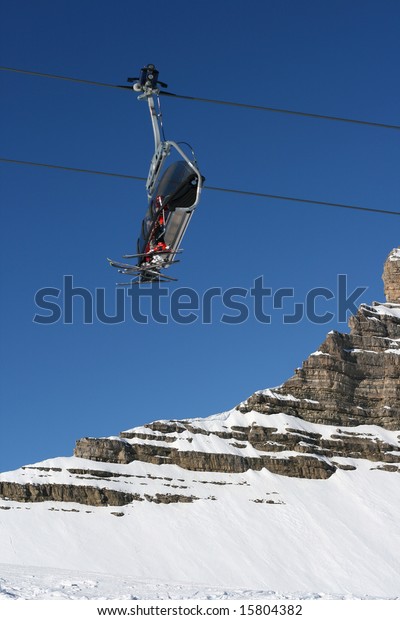 Ski lift chairs on\
bright winter day