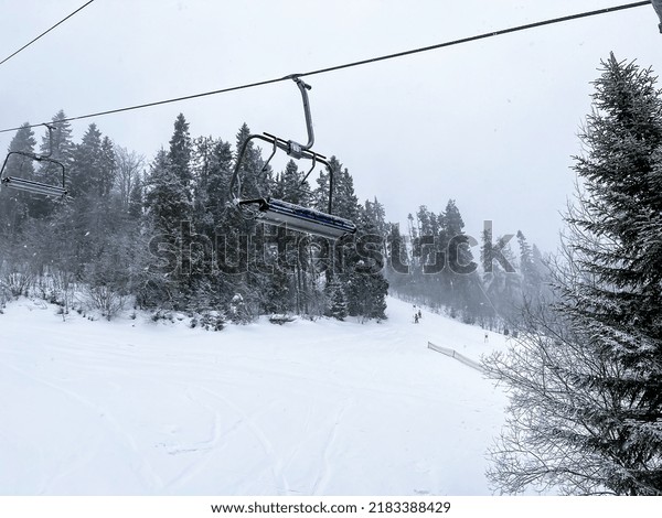 Ski Lift snowy mountain\
winter forest with chair lift At The Ski Resort in winter. Snowy\
weather Ski holidays Winter sport and outdoor activities Outdoor\
tourism 